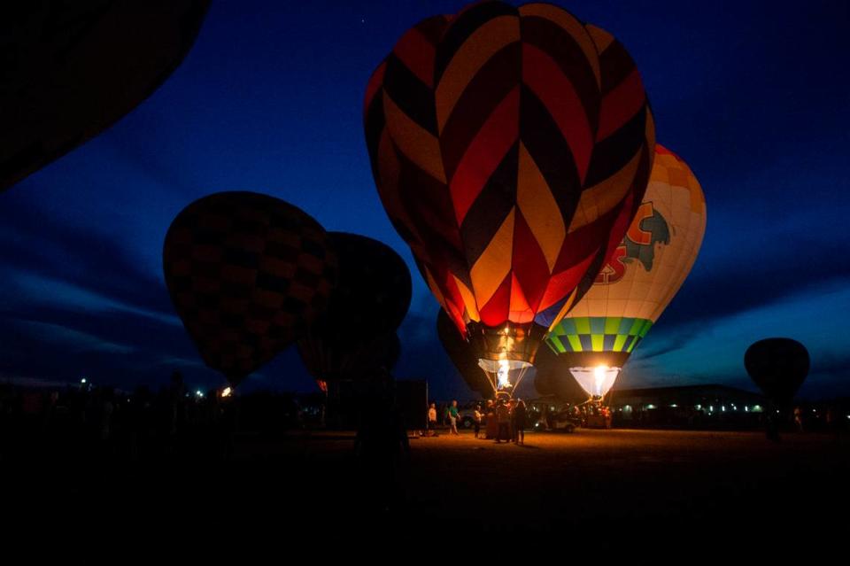 Hot air balloons fire their burners for a “balloon glow” during the Gulf Coast Hot Air Balloon Festival at OWA in Foley, Alabama on Thursday, May 4, 2023.