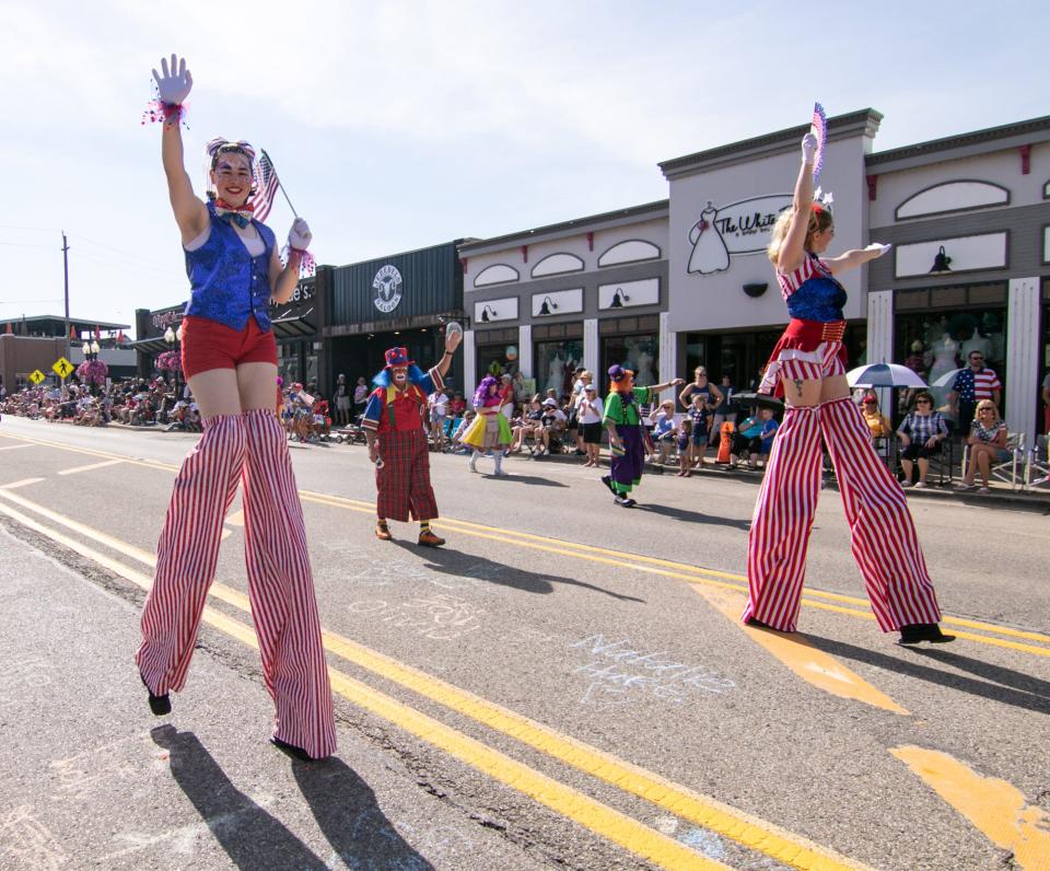 The Detroit Shrine clown unit and stilt walkers march down Main Street in the Brighton Fourth of July parade Monday, July 4, 2022.