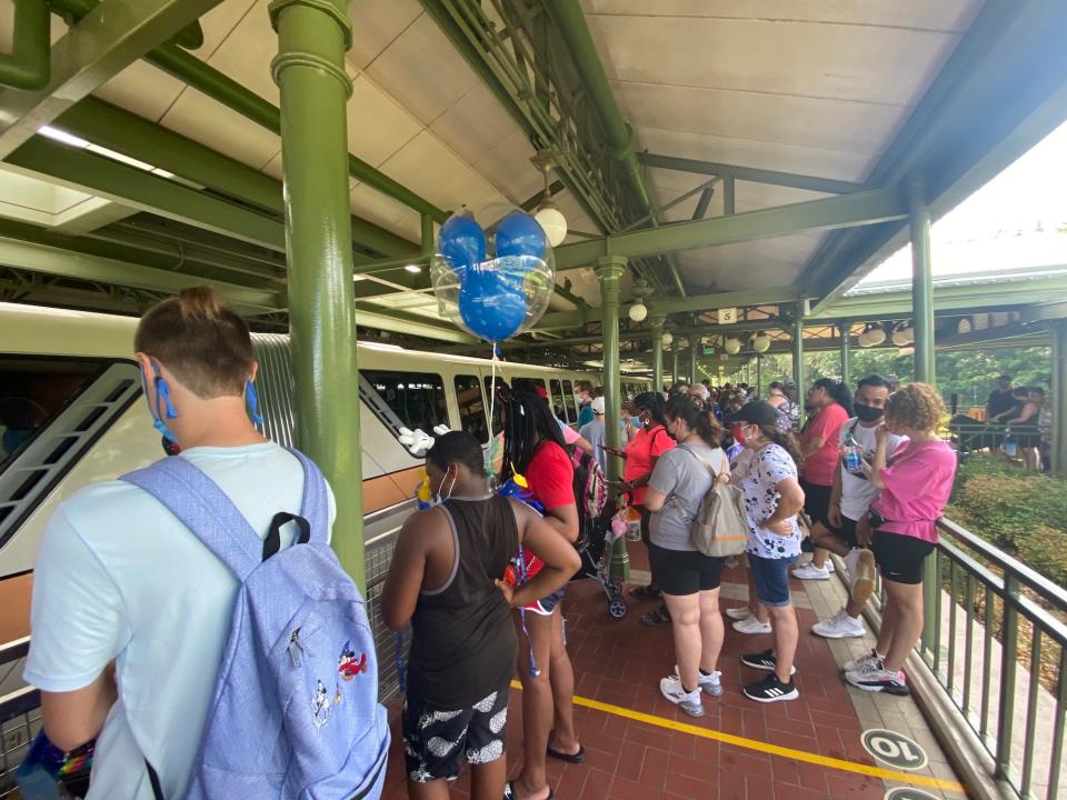 People wait for the monorail outside of Magic Kingdom.