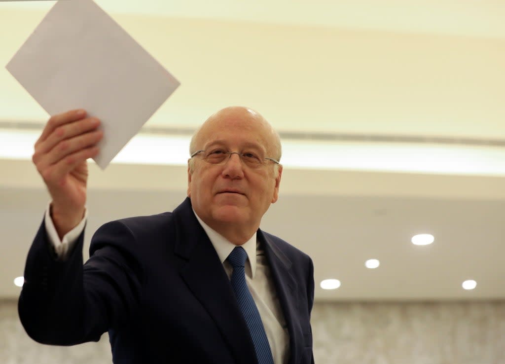 Lebanon's prime minister Najib Mikati holds the cabinet list after meeting with the country’s president Michel Aoun at the presidential palace in Baabda, Lebanon (Reuters)