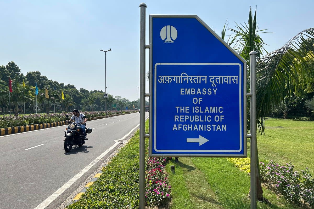A motorist rides past a sign board for the embassy of the Islamic Republic of Afghanistan in New Delhi (AFP via Getty Images)