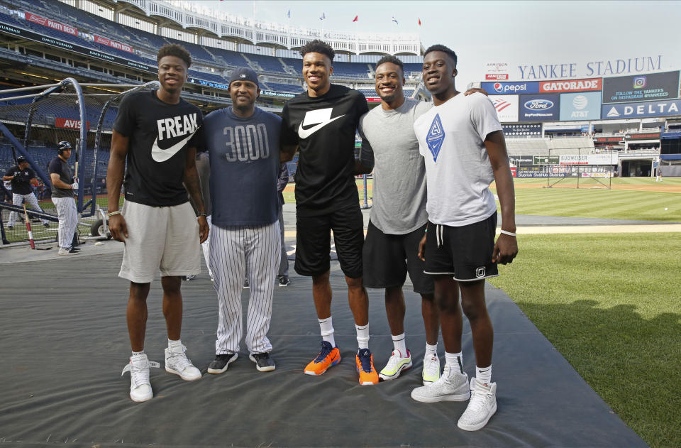 Milwaukee Bucks forward and 2019 NBA Most Valuable Player Giannis Antetokounmpo, center, and his three brothers, left, second from right, and right, pose for a photograph on the field with New York Yankees starting pitcher CC Sabathia, second from left, at Yankee Stadium before a baseball game between the Yankees and the Tampa Bay Rays, Monday, July 15, 2019, in New York. (AP Photo/Kathy Willens)