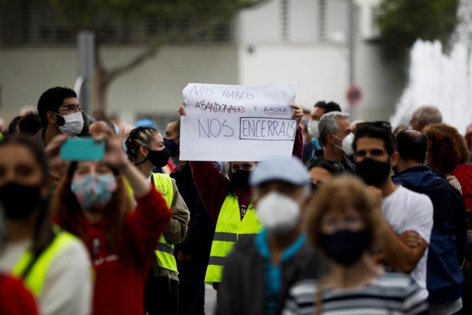 Participantes en la concentración frente a la Asamblea de Madrid que fue disuelta por la Policía. (Foto: EFE).