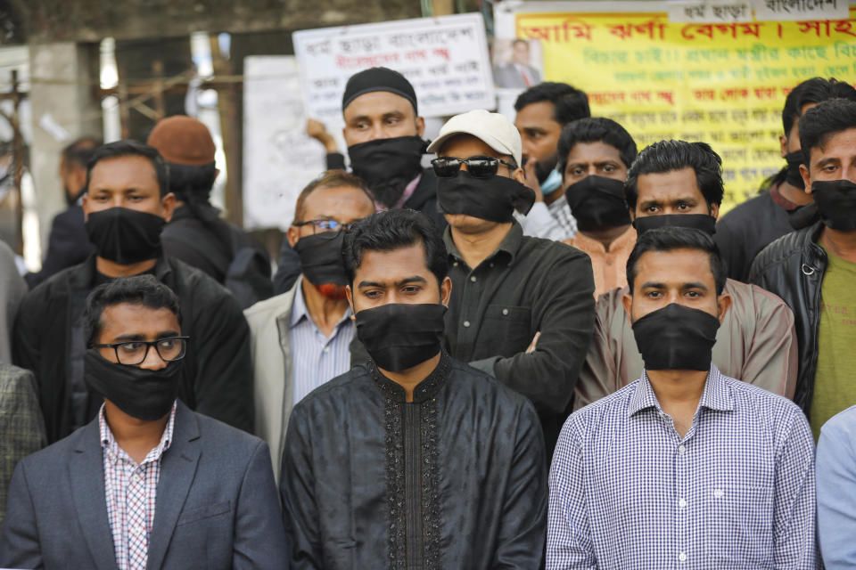 Activists of Gono Odhikar Parishad stand wearing black clothes on the face to protest against what they called a one sided election at the National Press Club in Dhaka, Bangladesh, Monday, Jan.8, 2024. Prime Minister Sheikh Hasina has won an overwhelming majority in Bangladesh's parliamentary election after a campaign fraught with violence and a boycott from the main opposition party, giving her and her Awami League a fourth consecutive term. (AP Photo/Mahmud Hossain Opu)