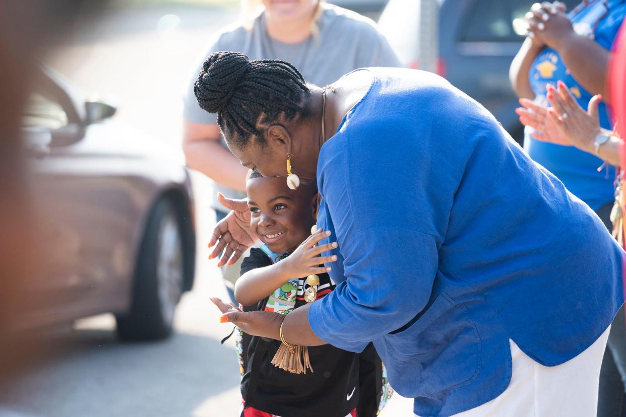 Jul 26, 2023; Columbus, Ohio, USA;  Woodcrest Elementary School Principal, Yolanda Cooper, gets a hug from first grader, Amani Estis, as teachers and staff clap in students on the first day of school. Woodcrest Elementary School is the district's only year-round school.