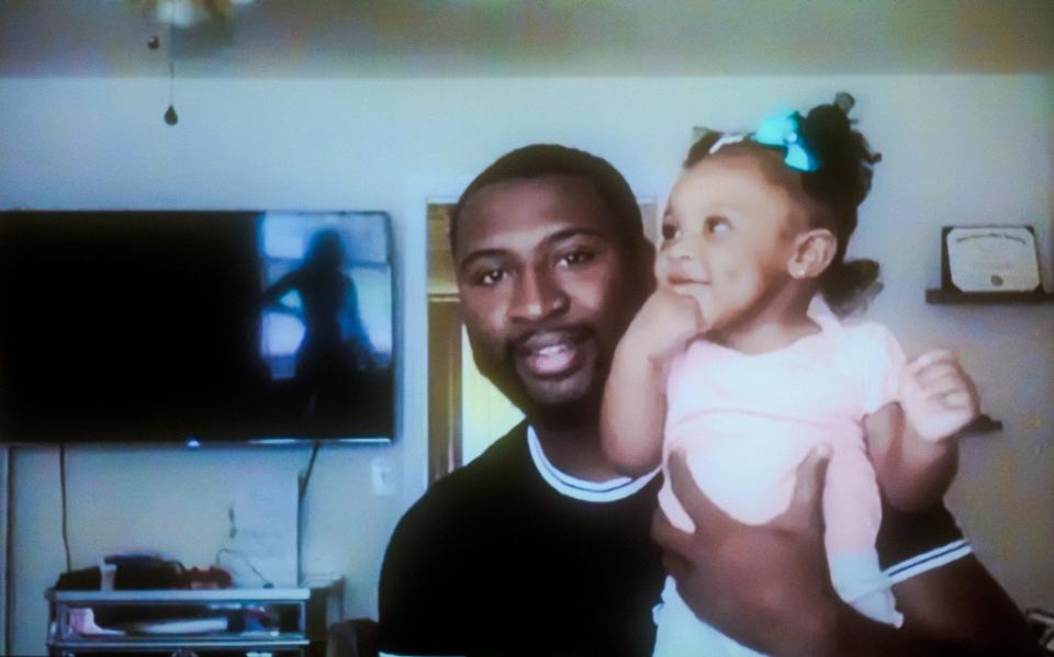 Will Lewis holds his baby daughter, Carmen, in his home in Riverdale, Georgia. “I want to be instrumental in her life in every way I can be, because I know I didn't get that,” Lewis said. “I had football games, award ceremonies … I looked up (at the stands) and nobody that I knew was there and everybody else’s family was cheering them on. It was very discouraging.” (Portrait taken remotely by Michele Abercrombie / News21)