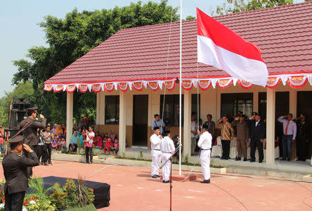 Former Islamist militants hoist the Indonesian flag at a ceremony to mark Independence Day at the Lingkar Perdamaian school in Tenggulun, East Java, Indonesia August 17, 2017. REUTERS/Tom Allard