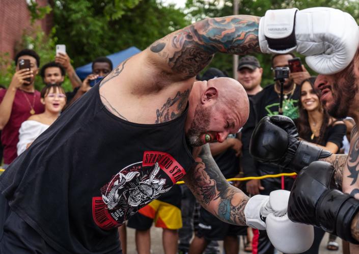 Ryan Rays, left, of Westland, launches himself at Jose Barba, of Detroit, while fighting during a Pick Your Poison Detroit event in Detroit&#39;s Delray neighborhood on Sunday, June 19, 2021.