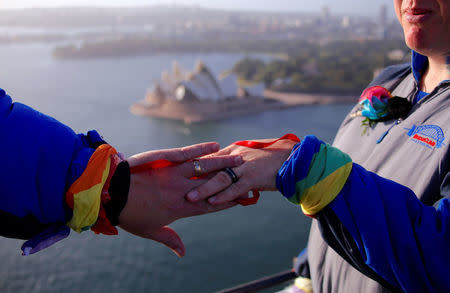 Warren Orlandi and Pauly Phillips display their rings after they became the first same-sex couple to marry atop of the Sydney Harbour Bridge, just two days out from the 40th anniversary of the Sydney Gay and Lesbian Mardi Gras, in Australia, March 1, 2018. REUTERS/David Gray