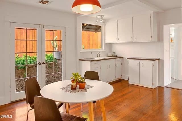 BEFORE: The owners asked for the existing French doors to be pared down to one frame so that the countertops could extend further across the wall. They asked to keep the Douglas fir flooring, so white oak cabinets were selected as a brighter contrast.