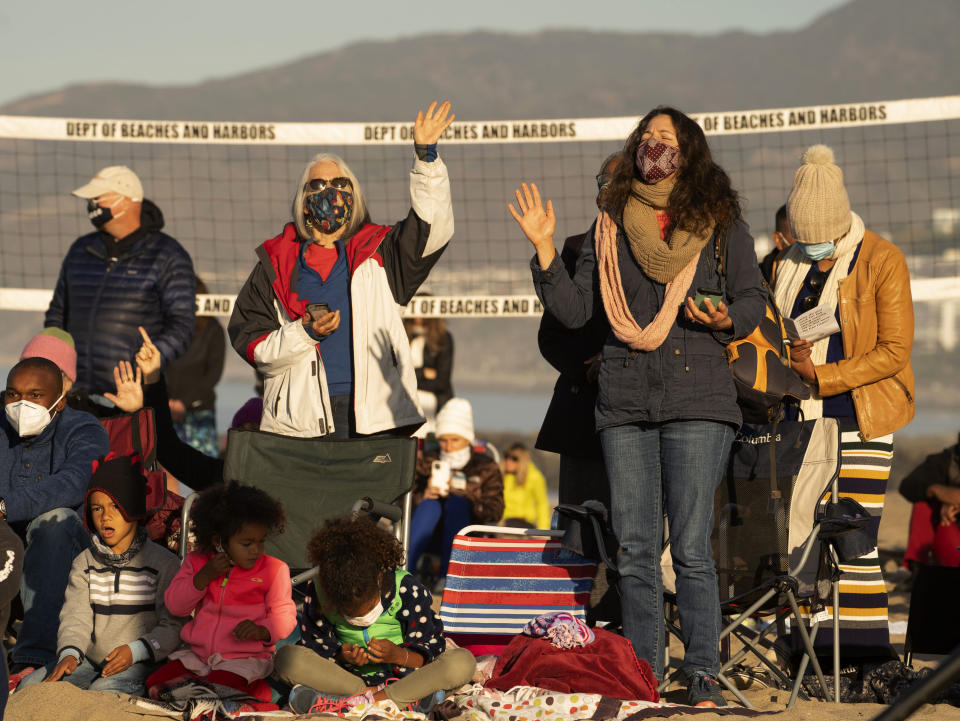 Members of the Veal family and friends join in praying during the Westside Easter Sunrise Service at Will Rogers State Beach park on the Santa Monica Bay on the Pacific Coast in the Pacific Palisades neighborhood of Los Angeles, Sunday, April 4, 2021. (AP Photo/Damian Dovarganes)