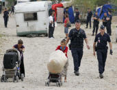 French CRS police evacuate families and remove their caravans from an illegal camp housing about 114 Roma, referred to as "Gens du Voyage", in Saint-Priest, near Lyon, Southeastern France, August 28, 2012. The French Interior minister said on Monday he would ask Romania and Bulgaria to do more to integrate their Roma minorities as the new government in Paris grapples with how to handle Roma immigrants in France. REUTERS/Robert Pratta (FRANCE - Tags: SOCIETY IMMIGRATION POLITICS)