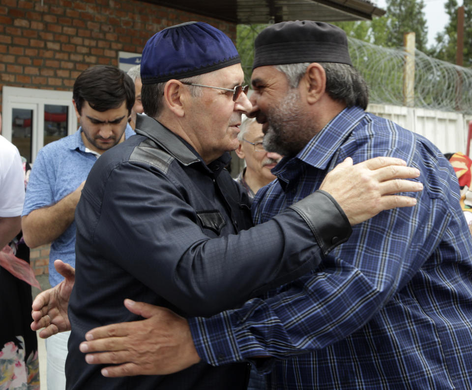 Oyub Titiev, the head of a Chechnya branch of the prominent human rights group Memorial, left, embraces his friend as he leaves a prison in Argun, Russia, Friday, June 21, 2019. Titiyev was released from a Russian prison on Friday morning, more than 18 months after first being detained on drug charges his supporters say were fabricated. (AP Photo/Musa Sadulayev)