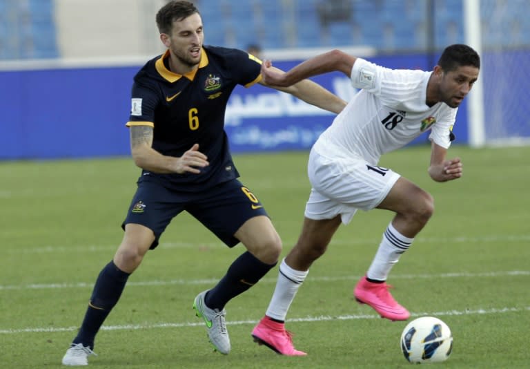 Jordan's Hasan Abdel-Fattah (C) dribbles past Australia's Matthew Spiranovic during the AFC qualifying football match for the 2018 FIFA World Cup on October 8, 2015 at the Amman International Stadium in the Jordanian capital