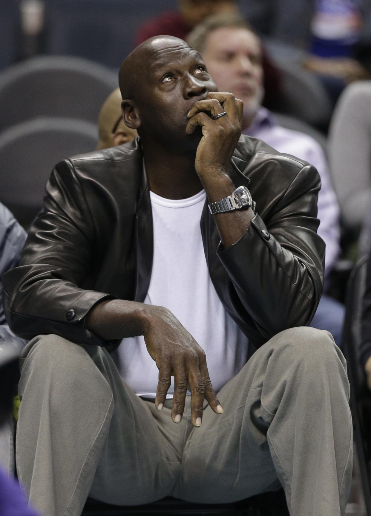 Charlotte Hornets owner Michael Jordan looks at a scoreboard in the first half of an NBA basketball game against the Portland Trail Blazers in Charlotte, N.C., Wednesday, Jan. 18, 2017. (AP Photo/Chuck Burton)