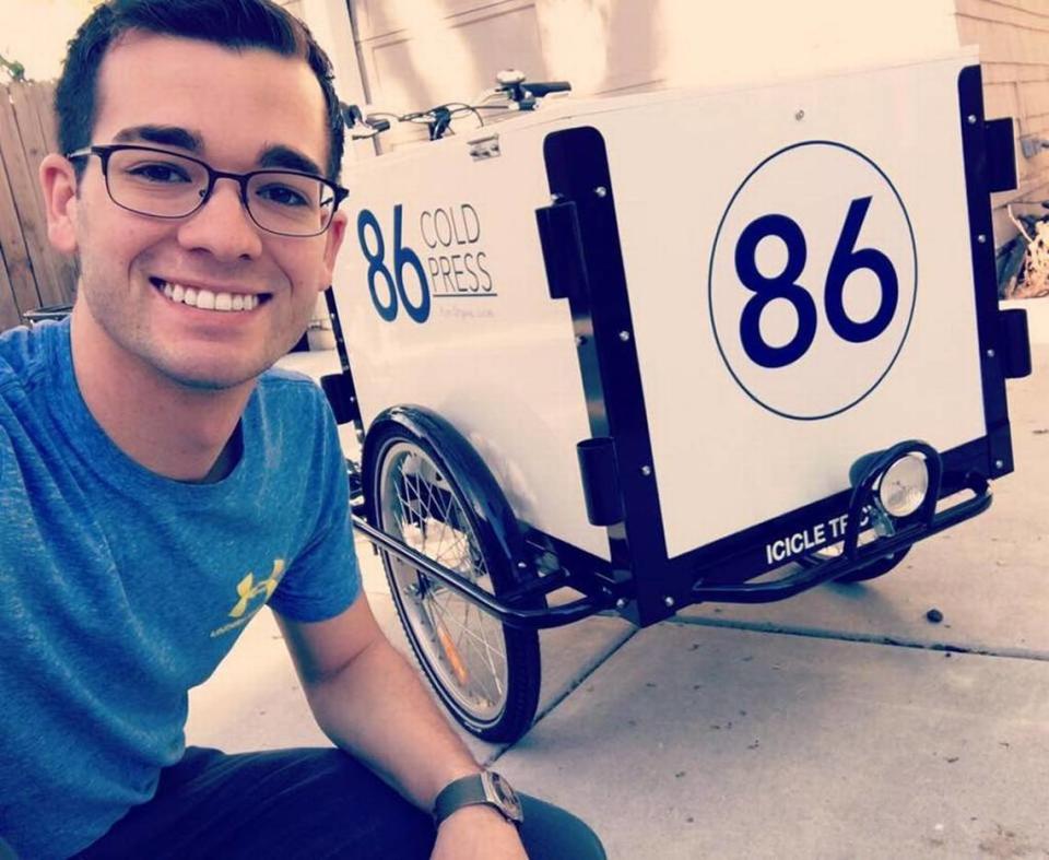 In the early days of 86 Cold Press, Austin Dugan sold his juices from a delivery bike hooked to a cart. This photo is from 2018. Courtesy photo