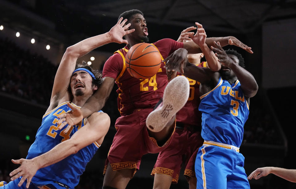 UCLA guard Jaime Jaquez Jr. (24) and forward Adem Bona (3) battle for a rebound with Southern California forward Joshua Morgan (24) and forward Kobe Johnson (0) during the first half of an NCAA college basketball game Thursday, Jan. 26, 2023, in Los Angeles. (AP Photo/Mark J. Terrill)