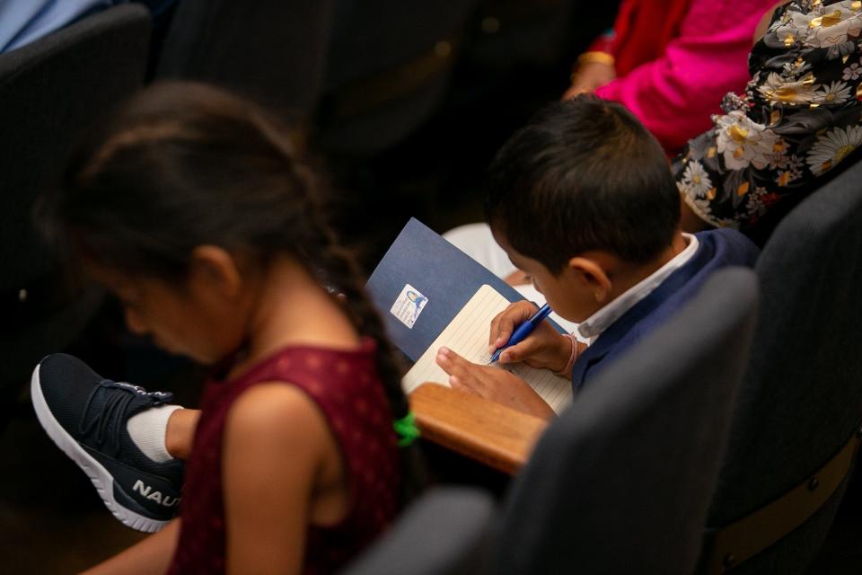 A young child writes in a notebook during the third International Bhutanese Literary Convention in Columbus. The Greater Columbus area is home to around 30,000 Bhutanese-Nepalis, according to the nonprofit Bhutanese Community of Central Ohio.