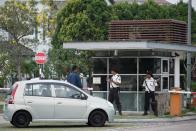 Security men guard the entrance to the residential complex where captain Zaharie Ahmad Shah, pilot of the missing Malaysia Airlines flight MH370, lives in Shah Alam, west of Kuala Lumpur, on March 15, 2014