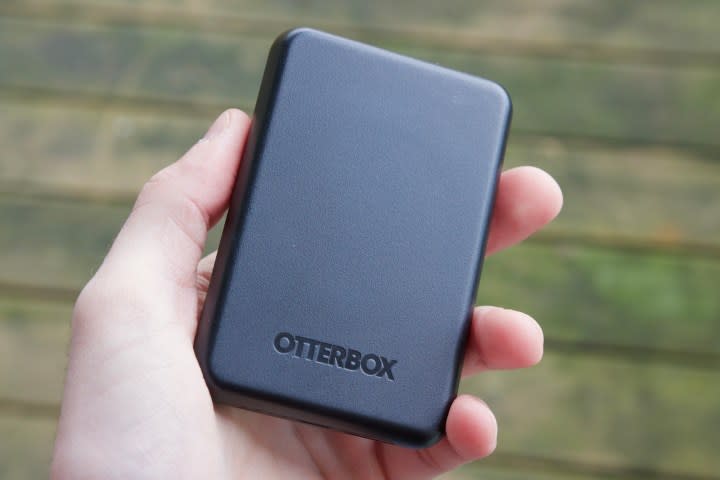 Someone holding a black OtterBox MagSafe power bank.
