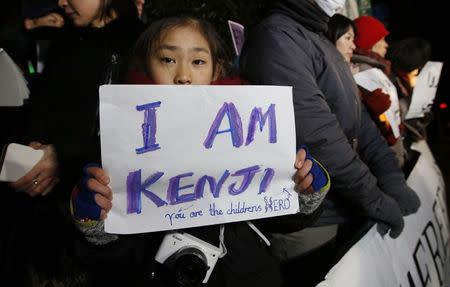 A girl holding a placard chant "Save Kenji" during a vigil in front of the Prime Minister Shinzo Abe's official residence in Tokyo, January 28, 2015. REUTERS/Toru Hanai