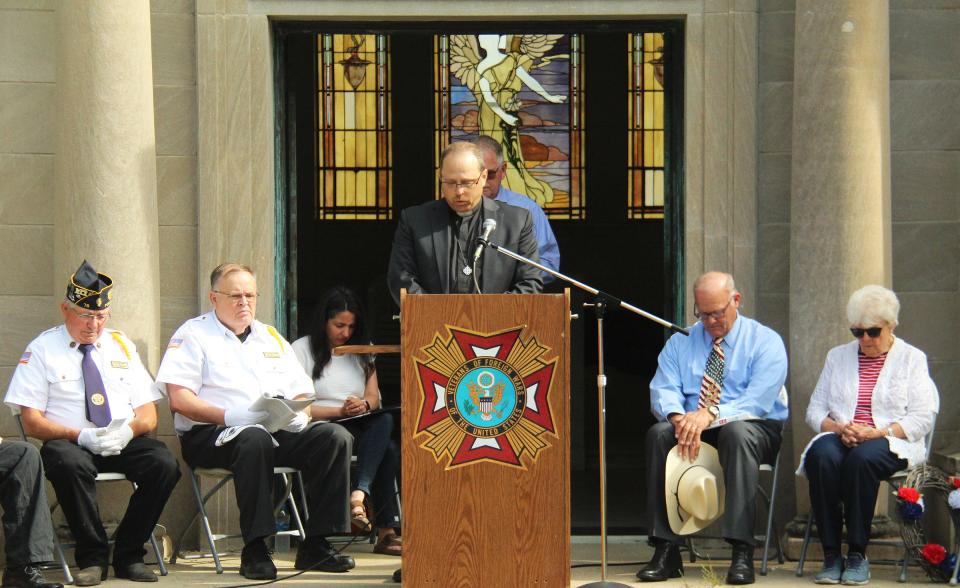 Rev. JD Buchenau gives the opening prayer for the Memorial Day service at Southside Cemetery Monday.