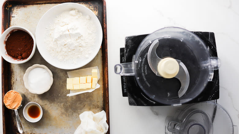 Dry cookie dough ingredients next to processor