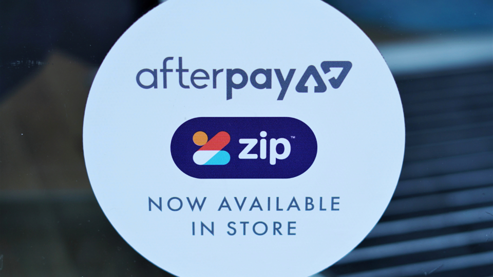 A sticker on a storefront indicating Afterpay and Zip are available in-store.