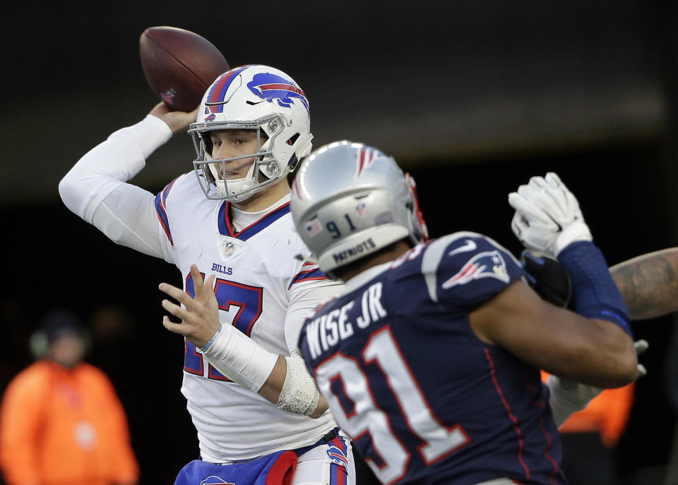 Buffalo Bills quarterback Josh Allen, left, passes under pressure from New England Patriots defensive end Deatrich Wise during the second half of an NFL football game, Sunday, Dec. 23, 2018, in Foxborough, Mass. (AP Photo/Steven Senne)