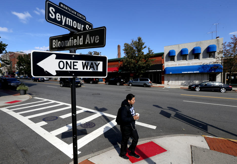 In this photograph taken Thursday, Oct. 18, 2012, in Montclair, N.J., a pedestrian walks in front of an establishment that will soon open as New Jersey's first medical marijuana dispensary. The opening of New Jersey's first state-authorized medical marijuana dispensary is delayed. The New Jersey Department of Health says that Greenleaf Alternative Treatment Center will not be ready to open for several weeks because it does not have its final certificate of occupancy from Montclair Township. (AP Photo/Julio Cortez)