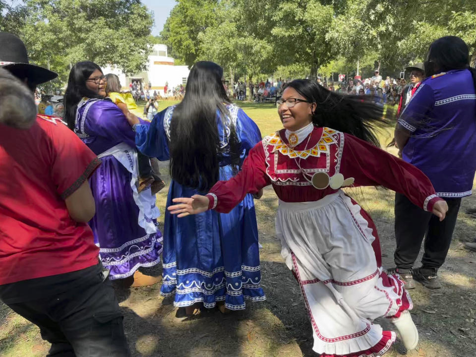 Isley Phillips, 18, chases her brother Noah, 19, and his racoon-tail hat as part of their traditional Racoon Dance, on Saturday, Sept. 17, 2022, in Macon, Ga. The teenagers are members of the Mississippi Band of Choctaw Indians, and performed at the 30th annual Ocmulgee Indigenous Celebration at the Ocmulgee Mounds. (AP Photo/Michael Warren)