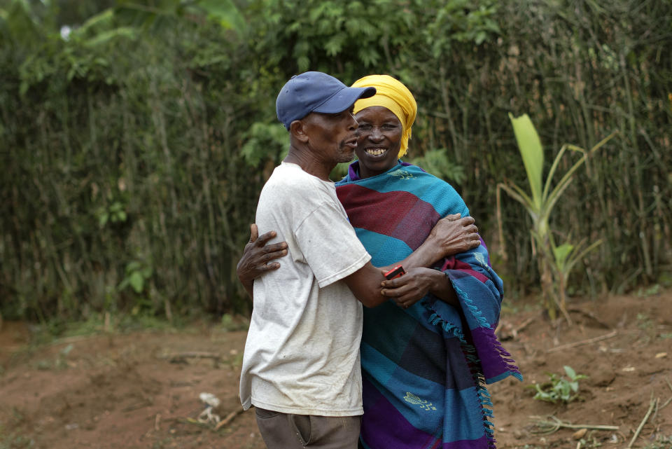 In this photo taken Thursday, April 4, 2019, genocide survivor Laurencia Mukalemera, right, a Tutsi, greets Tasian Nkundiye, left, a Hutu who murdered her husband and spent eight years in prison for the killing and other crimes, at Nkundiye's home in the reconciliation village of Mbyo, near Nyamata, in Rwanda. Twenty-five years after the genocide the country has six "reconciliation villages" where convicted perpetrators who have been released from prison after publicly apologizing for their crimes live side by side with genocide survivors who have professed forgiveness. (AP Photo/Ben Curtis)