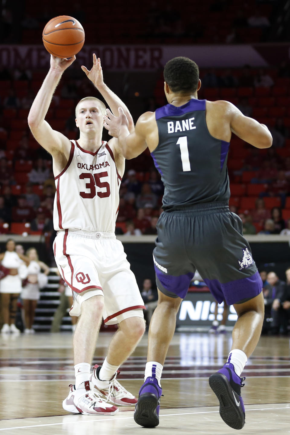 Oklahoma's Brady Manek (35) passes the ball as TCU's Desmond Bane (1) defends during the second half of an NCAA college basketball game in Norman, Okla., Saturday, Jan. 18, 2020. (AP Photo/Garett Fisbeck)