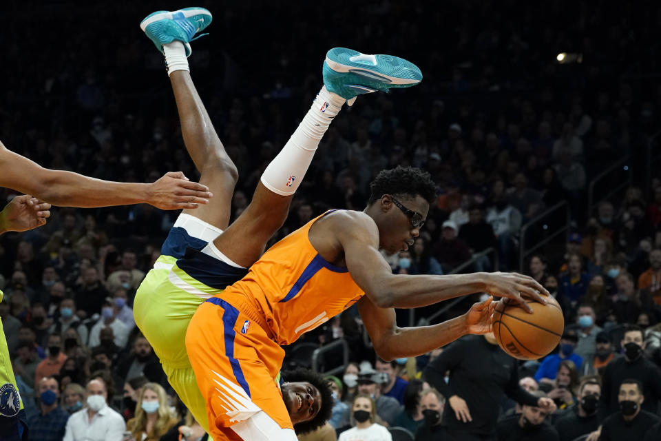 Minnesota Timberwolves forward Jaden McDaniels fouls Phoenix Suns forward Jalen Smith, right, during the second half of an NBA basketball game, Friday, Jan. 28, 2022, in Phoenix. The Suns defeated the Timberwolves 134-124. (AP Photo/Matt York)