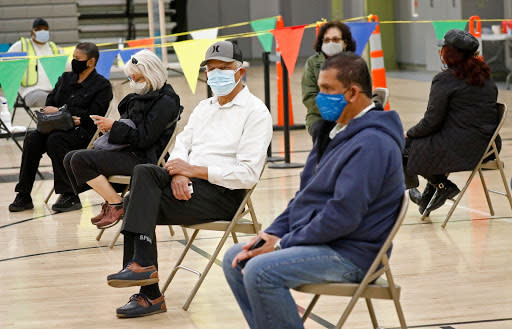 Feb. 17: In Los Angeles, California, Grand High School teaching assistant Alfredo R. Fong and bus driver Devan Nanayakkara, wait before receiving their COVID-19 vaccination as school district employees received their first dose of the vaccine. (Getty Images)