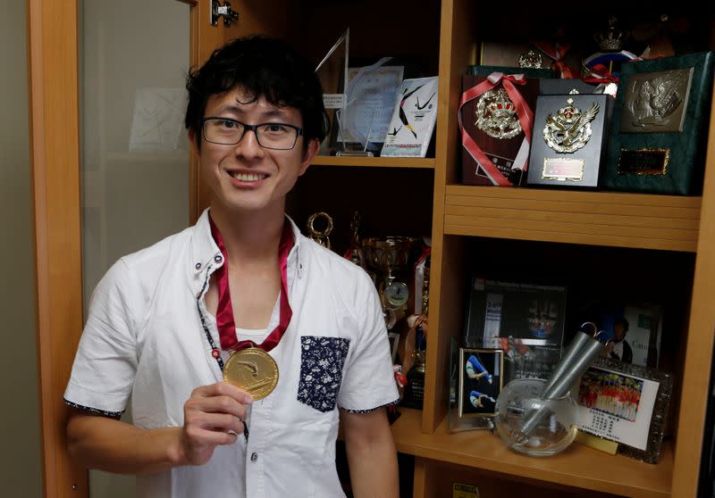 Former Japanese Olympic Trampolinist Tetsuya Sotomura poses with one of the medals he won, amid the coronavirus disease (COVID-19) pandemic in Saitama