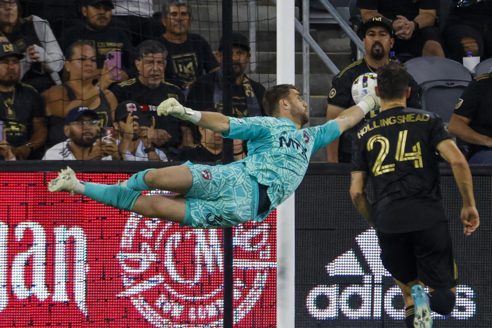 FC Dallas goalkeeper Maarten Paes, left, makes a save in front of Los Angeles FC defender Ryan Hollingshead (24) during the first half of an MLS soccer match in Los Angeles, Wednesday, June 29, 2022. (AP Photo/Ringo H.W. Chiu)