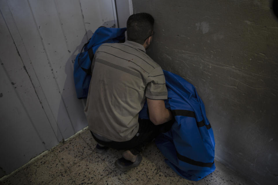 The father of 12 year-old Rahaf al-Dayer holds her covered body at the Shifa Hospital, after she was killed in an Israeli airstrike that destroyed the upper floors of a commercial building and caused damage to the nearby Health Ministry and prime health care clinic, in Gaza City, Monday, May 17, 2021. (AP Photo/Khalil Hamra)