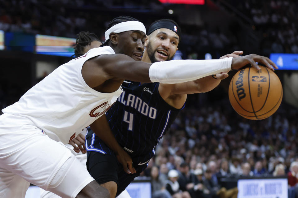 Cleveland Cavaliers guard Caris LeVert, left, and Orlando Magic guard Jalen Suggs (4) reach for the ball during the second half of Game 2 of an NBA basketball first-round playoff series, Monday, April 22, 2024, in Cleveland. (AP Photo/Ron Schwane)