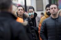 A woman wears a protective mask as she walks on Oxford Street in London
