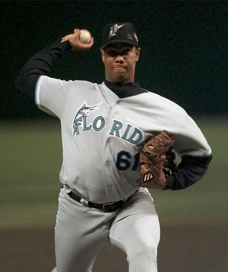 FILE - In this Thursday, Oct. 23, 1997 file photo,Florida Marlins Livan Hernandez pitches to the Cleveland Indians in the first inning of Game 5 of the World Series at Cleveland's Jacobs Field. Cubans can sign under rules similar to what players from Japan, South Korea and Taiwan face, according to a new agreement between Major League Baseball, its players’ association and the Cuban Baseball Federation. Players from Cuba would be allowed to sign big league contracts without defecting. (AP Photo/Ed Reinke, File)