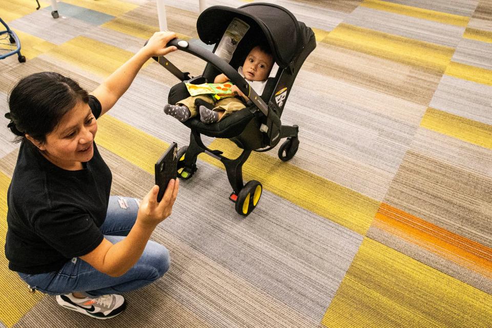 Arando Cinto Juarez, with her 8-month old son, Isac Juarez, takes a photo after her English class at Milton Elementary School in Milton, Thursday, Oct. 26, 2023.