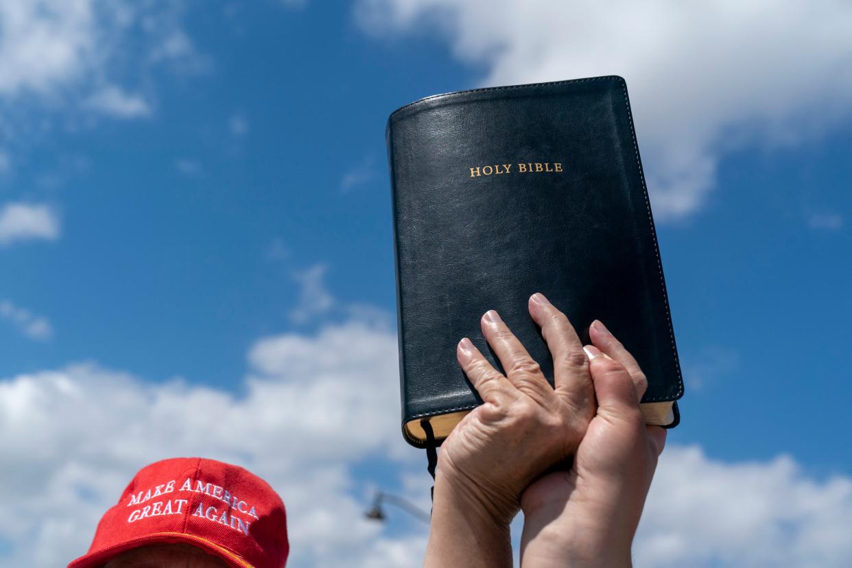 Former president Donald Trump supporters hold up a bible  across from Mar-a-Lago in Palm Beach, Florida on March 21, 2023.