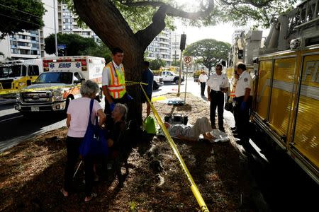 Paramedics help a resident of the Marco Polo apartment building after a fire broke out in it in Honolulu, Hawaii, July 14, 2017. REUTERS/Hugh Gentry