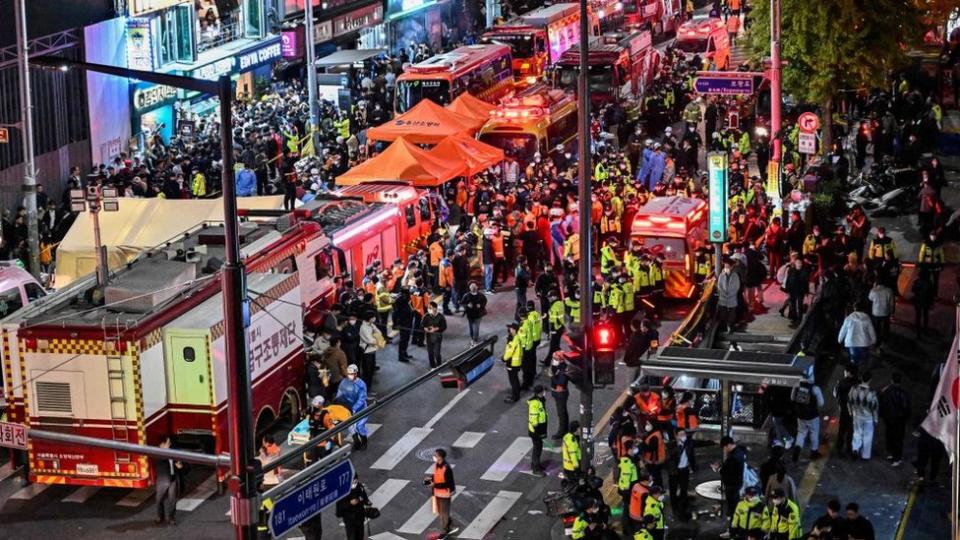 Coches de emergencias, agentes de seguridad y gente.