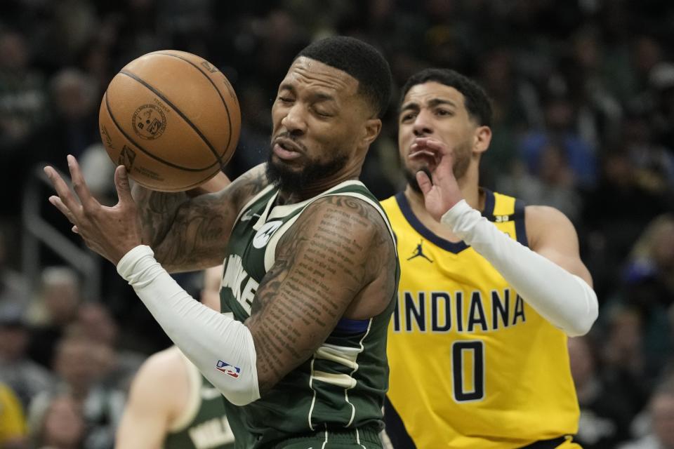 Milwaukee Bucks' Damian Lillard grabs a rebound in front of Indiana Pacers' Tyrese Haliburton during the second half of Game 1 of the first round NBA playoff basketball game Sunday, April 21, 2024, in Milwaukee. The Bucks won 109-94 to take a 1-0 lead in the series. (AP Photo/Morry Gash)