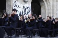 Striking musicians perform outside the Palais Garnier opera house, Saturday, Jan. 18, 2020 in Paris. As some strikers return to work, with notable improvements for train services that have been severely disrupted for weeks, more radical protesters are trying to keep the movement going. (AP Photo/Kamil Zihnioglu)