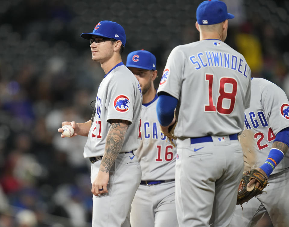 Chicago Cubs relief pitcher Ethan Roberts, left, waits to be pulled from the mound after walking Colorado Rockies' Ryan McMahon with the bases loaded to force in a run in the fifth inning of a baseball game Thursday, April 14, 2022, in Denver. (AP Photo/David Zalubowski)