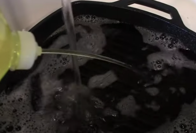 Washing cast-iron skillet with soapy water