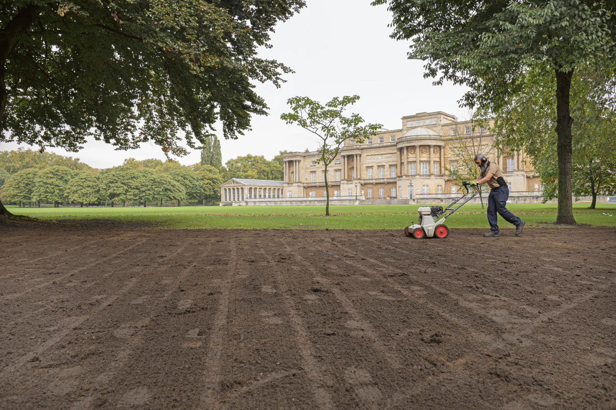 For single use only in connection with Buckingham Palace: A Royal Garden, not to be archived, sold on or used out of context. Undated handout photo issued by the Royal Collection Trust of a member of the gardening team at Buckingham Palace, London, tending to the lawns that are usually in need of repair after a busy summer of use for royal events. The secret of how the Buckingham Palace garden is kept so immaculate is subject of a new behind the scenes book, Buckingham Palace: A Royal Garden, which charts a year in the life of the 39-acre oasis, which boasts sweeping lawns, a 156-metre herbaceous border, wildflower meadows, a rose garden and a 3.5-acre lake. Issue date: Tuesday February 23, 2021.